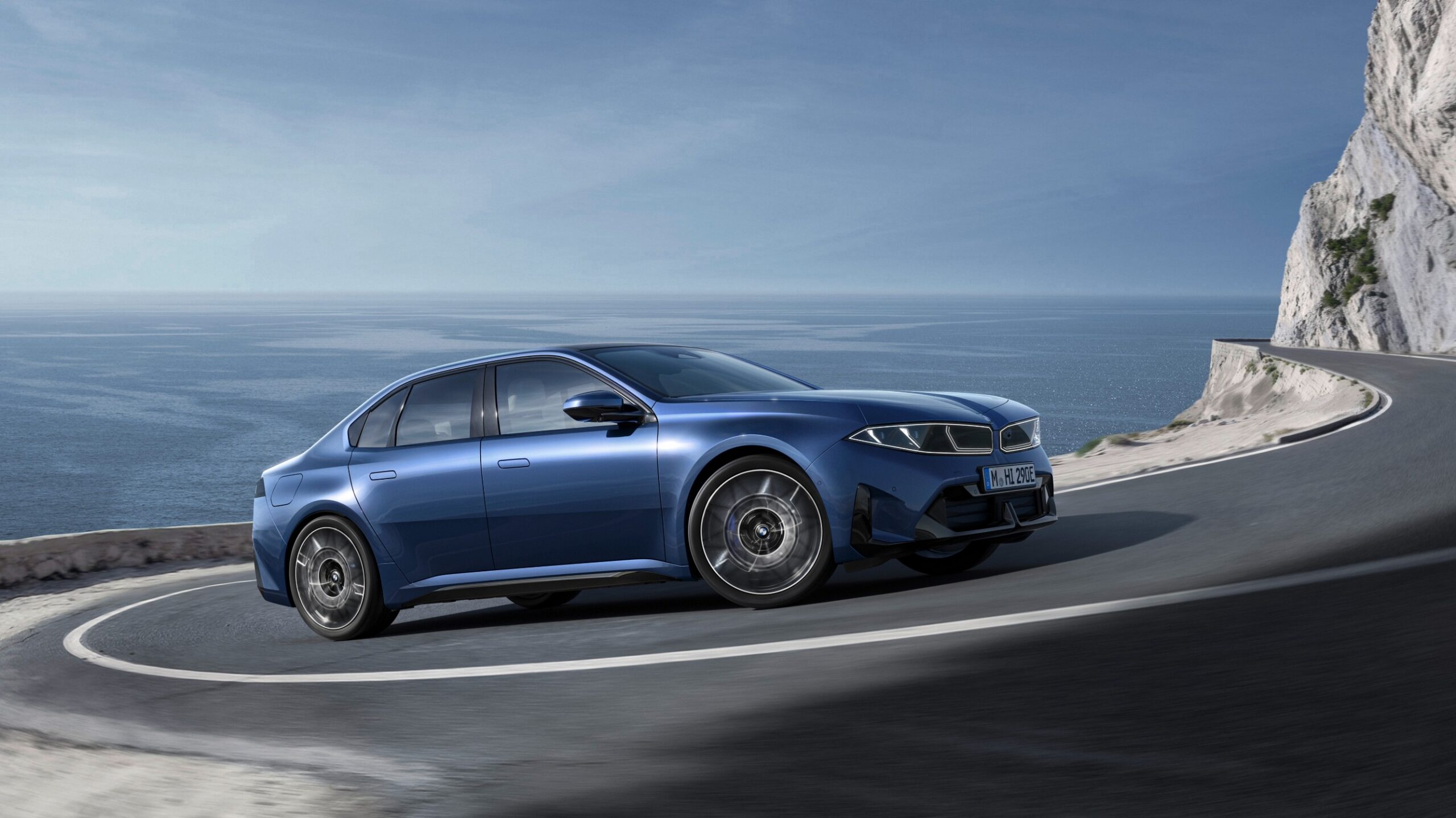 Blauer BMW i3 f&auml;hrt eine Stra&szlig;e bergauf