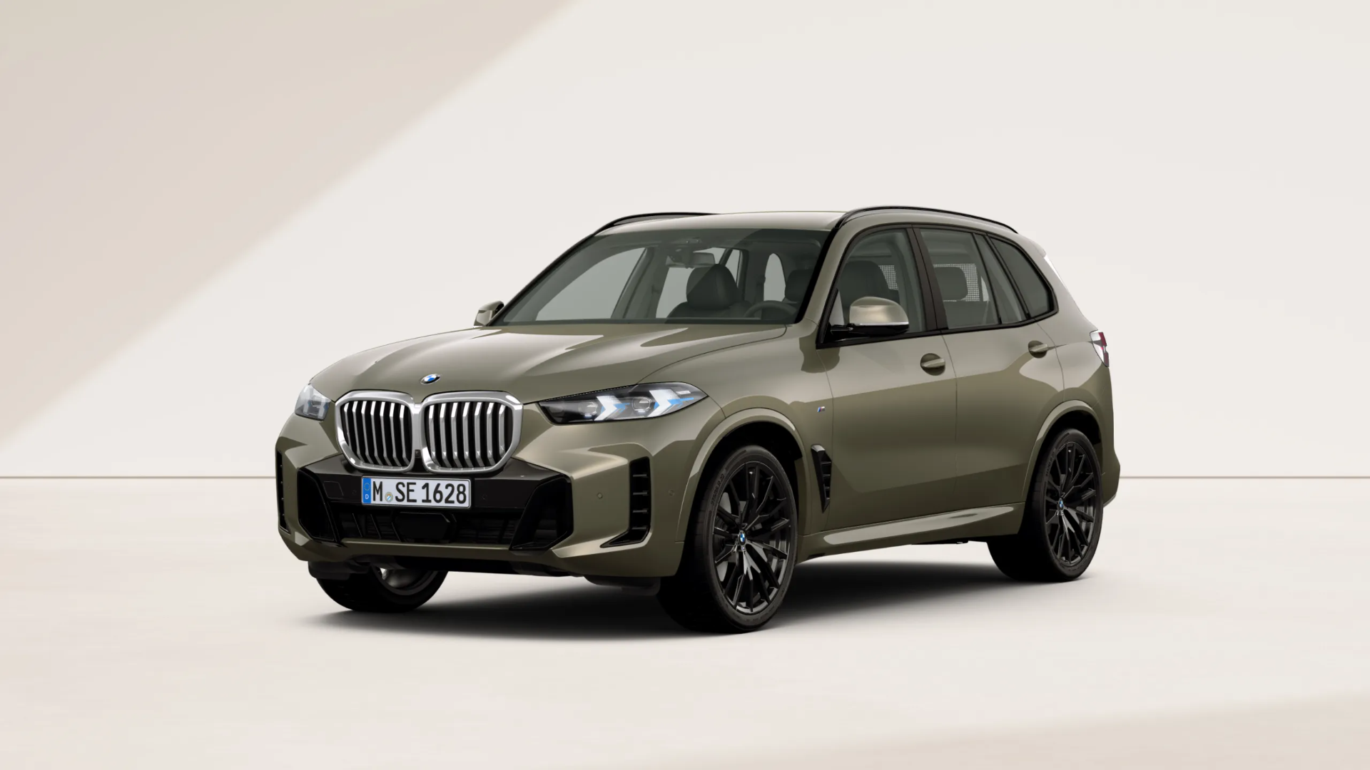 Dunkelgrüner BMW X5 vor einem beigen Hintergrund