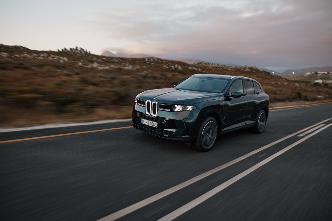 Der neue BMW X5 f&auml;hrt auf einer Stra&szlig;e in der D&auml;mmeung.