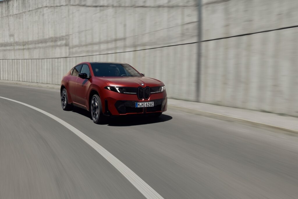 Roter BMW iX4 fährt auf einer Straße