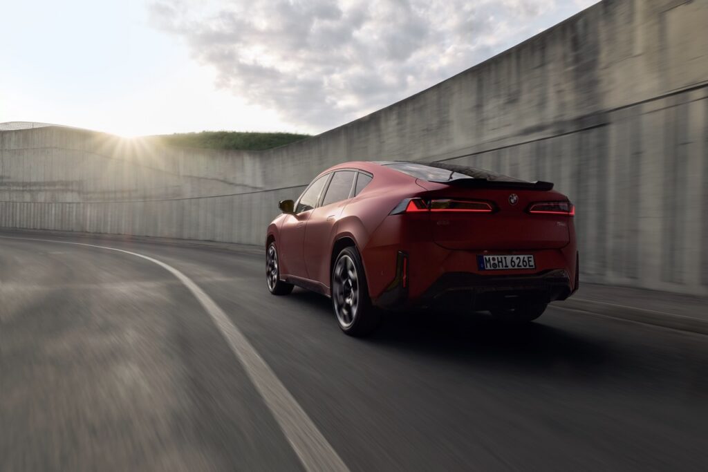 Roter BMW iX4 fährt auf einer Straße